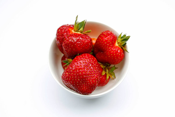 Juicy strawberries in a bowl on a white background - Фото, зображення