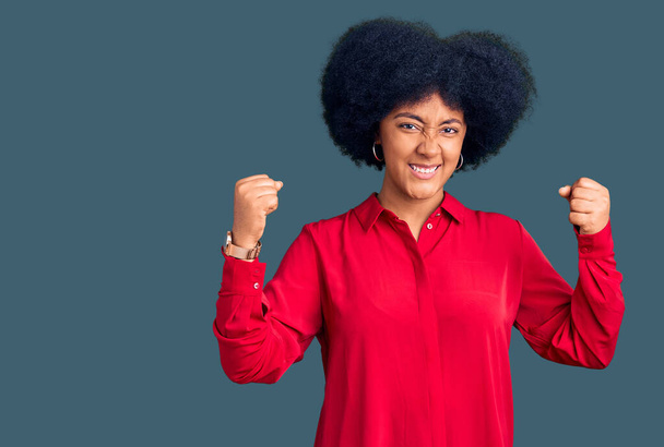 Kızgın ve kızgın giyinmiş genç Afro-Amerikalı kız öfkeyle bağırırken kızgın ve öfkeli yumruklar sallıyor. öfke ve agresif konsept.  - Fotoğraf, Görsel