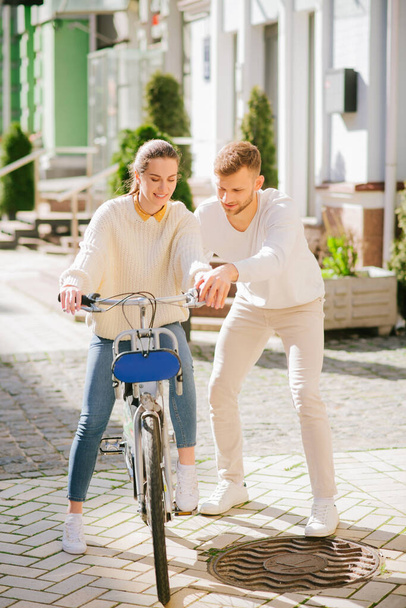 Woman learning riding a bike and a man helping her - Foto, immagini