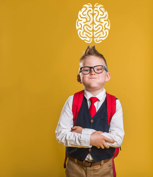 Enfant drôle en uniforme scolaire et sac avec photo du cerveau ci-dessus - Photo, image