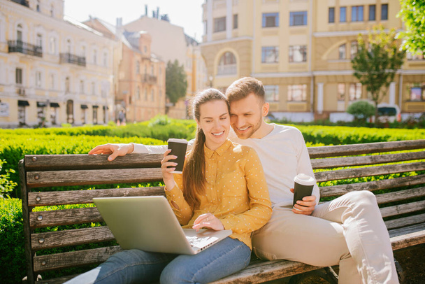 Woman with laptop and man with coffee looking at screen - Foto, Bild