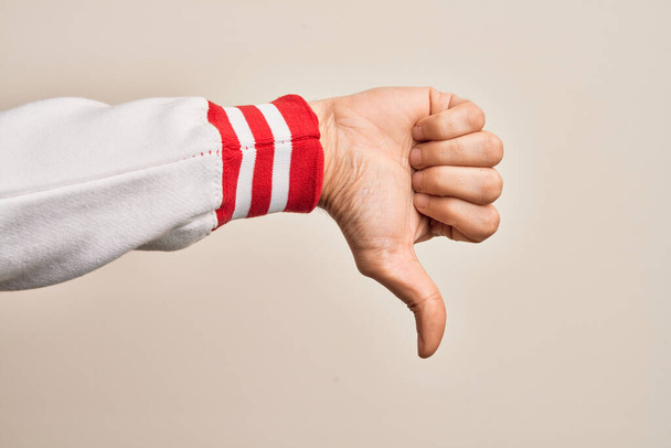 Рука білошкірого чоловіка, який показує пальці над ізольованим білим тлом, робить великі пальці вниз жестом відторгнення, не схвалює нелюбов і негативний знак
 - Фото, зображення