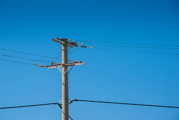 High voltage tower.  electricity wire supply. electrical industry transmission technology against clear blue sky. energy distribution pylon. Power cable line infrastructure pole. Urban construction - Photo, image