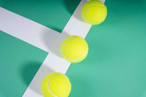 Top view - Τρεις μπάλες του τένις στο πράσινο γήπεδο. Αθλητική έννοια. - Φωτογραφία, εικόνα