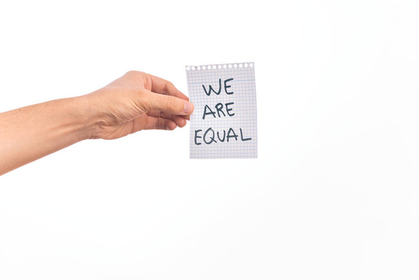 Cardboard banner WE ARE EQUAL, protesting for equal rights over isolated white background - Фото, изображение
