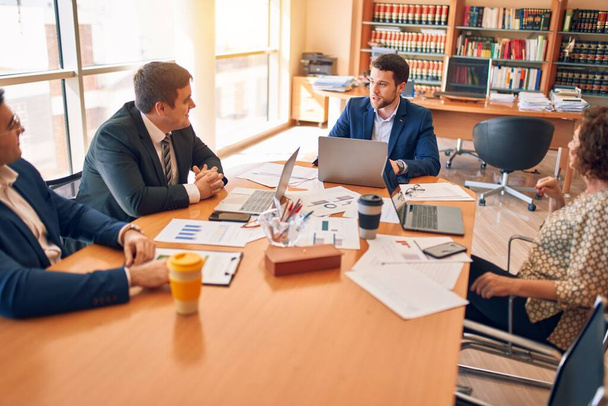 Avocats d'affaires travailleurs se réunissant au cabinet d'avocats. Partenaires exécutifs professionnels travaillant sur la stratégie financière sur le lieu de travail - Photo, image