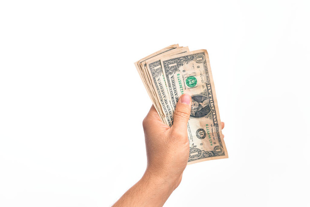 Hand eines kaukasischen jungen Mannes mit einem Bündel Dollarnoten vor isoliertem weißem Hintergrund - Foto, Bild