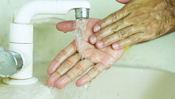 chef lavando la mano bajo agua corriente
. - Foto, imagen