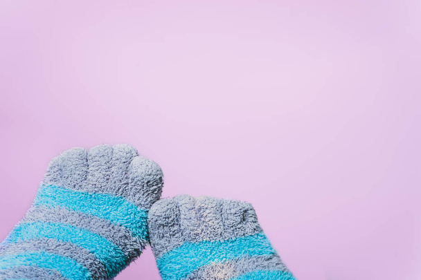 ピンクの背景に別の指で縞模様の靴下。週末に足のための快適な服 - 写真・画像