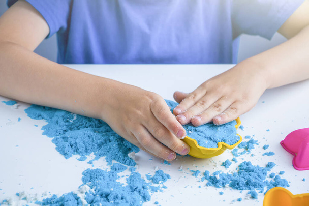 Kids creativity. Kinetic sand games for child development at home. Sand therapy. Children's hands making moldes. Selective focus, backlight - Fotó, kép