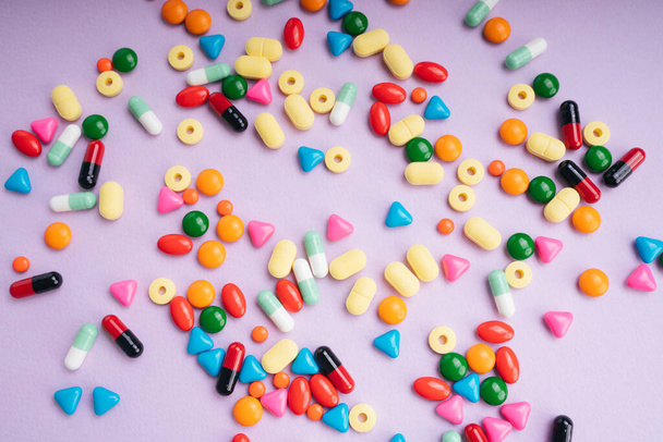 Visão superior - comprimidos de medicamentos coloridos sobre fundo pastel
. - Foto, Imagem