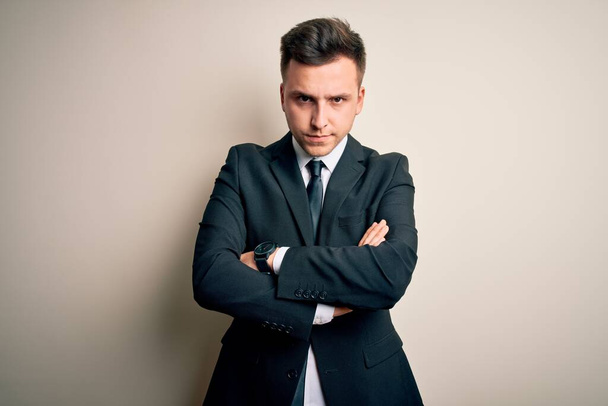 Young handsome business man wearing elegant suit and tie over isolated background skeptic and nervous, disapproving expression on face with crossed arms. Negative person. - Photo, Image