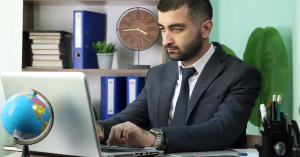 Giovane uomo d'affari che lavora su un computer portatile in un ufficio moderno - Filmati, video
