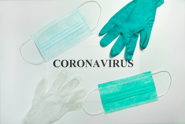 Медицинские защитные маски с перчатками на столе со словом Коронавирус
 - Фото, изображение