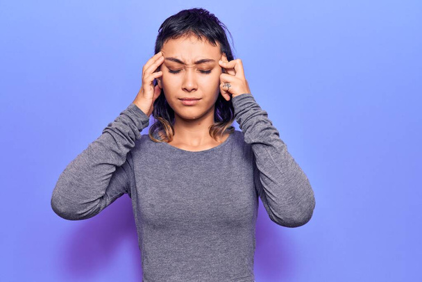 Egy fiatal nő alkalmi ruhát visel, kezével a fején, fejfájás, mert stresszes. migrénben szenved.  - Fotó, kép