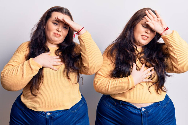 Young plus size twins wearing casual clothes touching forehead for illness and fever, flu and cold, virus sick  - Fotó, kép