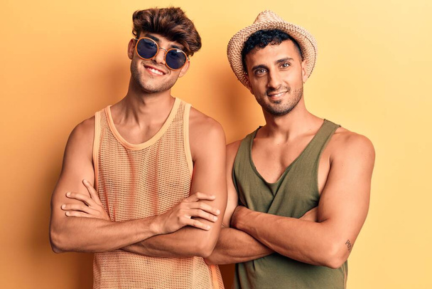 Joven pareja gay vistiendo ropa de verano cara feliz sonriendo con los brazos cruzados mirando a la cámara. persona positiva
.  - Foto, imagen