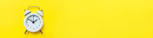 Simplement design minimal sonnerie jumelle réveil classique Isolé sur fond jaune. Heures de repos temps de la vie bonjour nuit réveil concept éveillé. Bannière plate d'espace de copie de vue de dessus - Photo, image