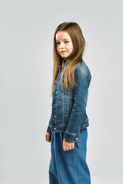 Portrait of a pretty little girl. child in a denim suit. Studio photography - Фото, изображение