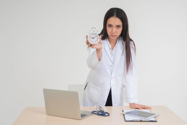 Молода жінка-лікар тримає білий годинник. Концепція охорони здоров'я легше, ніж лікування хвороб
. - Фото, зображення