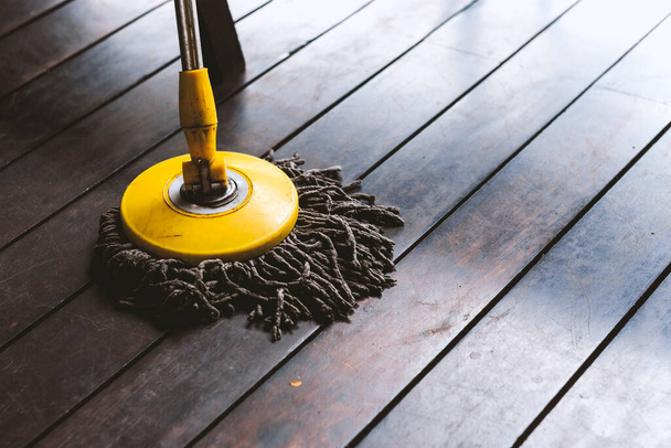 close-up dweil reinigen van houten vloer met soft-focus en over licht op de achtergrond - Foto, afbeelding