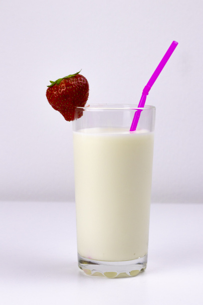bicchiere di latte con fragole e un tubo su fondo bianco - Foto, immagini