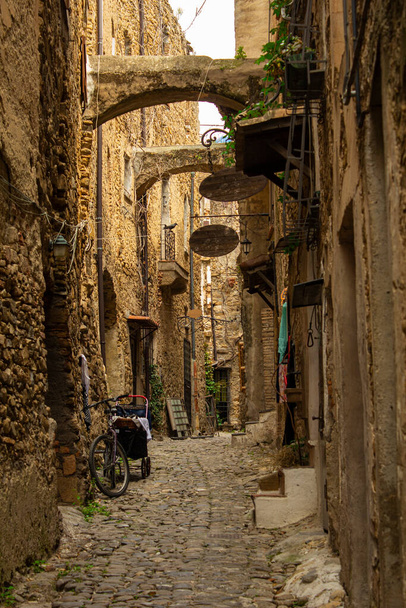 Smalle en mysterieuze weg in een bergstadje. Smalle straat met huizen en muren gemaakt van steen en oude kasseien. - Foto, afbeelding