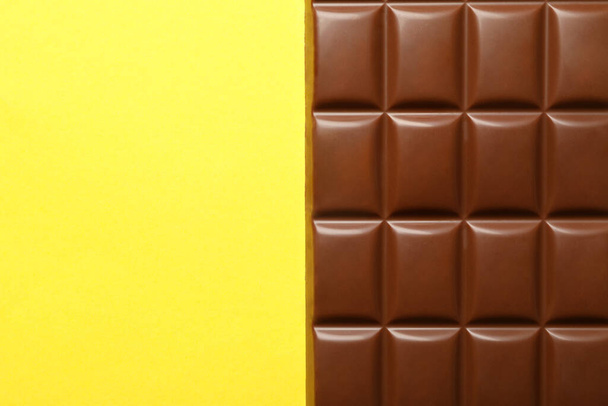Tasty chocolate bar on yellow background. Sweet food - Photo, Image