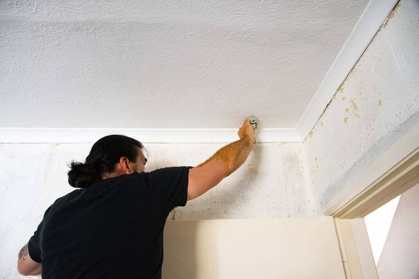 Человек ремонт стен штукатурки трещин в стене интерьер
  - Фото, изображение