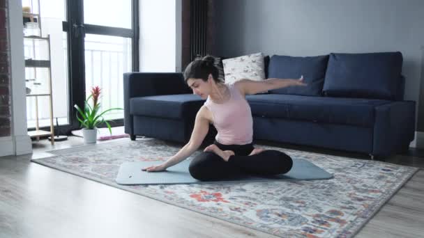 Relaxed woman practicing yoga exercises sitting on floor in oriental interior. - Filmati, video
