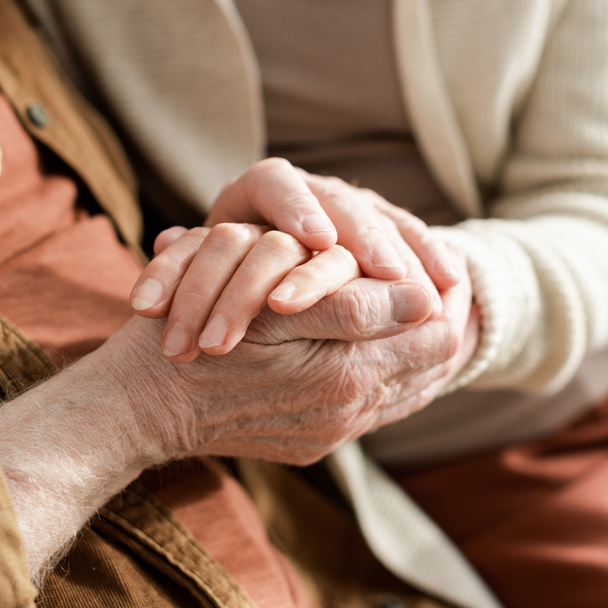 przycięty widok pary seniorów trzymających się za ręce, selektywne skupienie - Zdjęcie, obraz