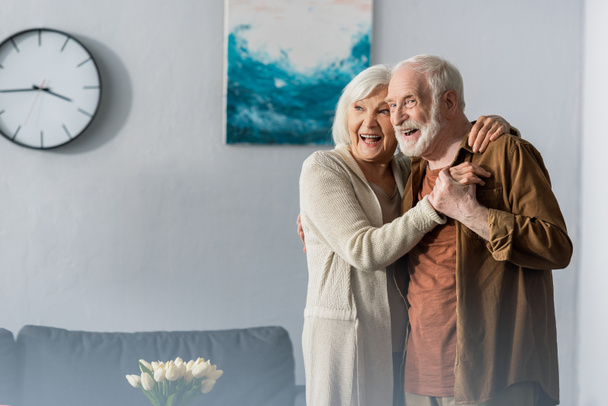 happy senior couple dancing at home and looking away - Fotoğraf, Görsel