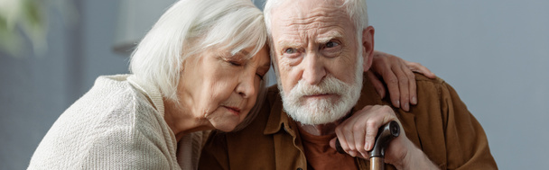 imagen horizontal de la mujer mayor con los ojos cerrados abrazando marido, enfermo de demencia
 - Foto, Imagen