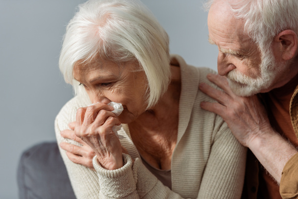 hombre mayor tocando hombro de esposa llorando sosteniendo servilleta de papel
 - Foto, imagen