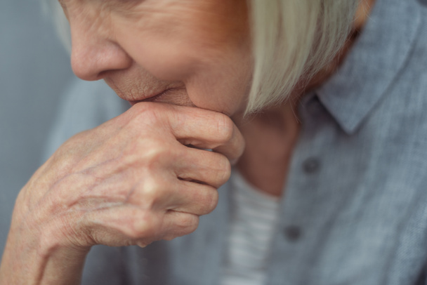 vista ritagliata della donna anziana solitaria che tiene la mano vicino al mento - Foto, immagini