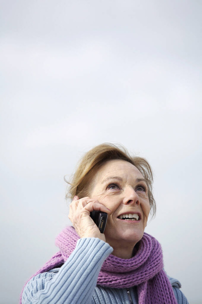 A woman smiling and talking on the mobile - Foto, afbeelding