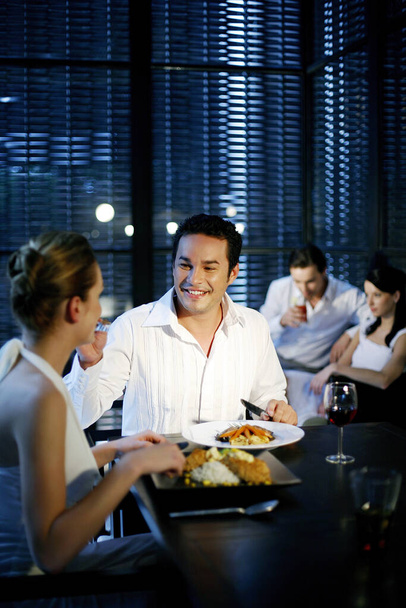Man feeding his girlfriend while having dinner in a restaurant - Valokuva, kuva