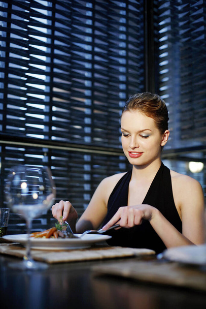 Woman enjoying her meal in a luxurious restaurant - 写真・画像