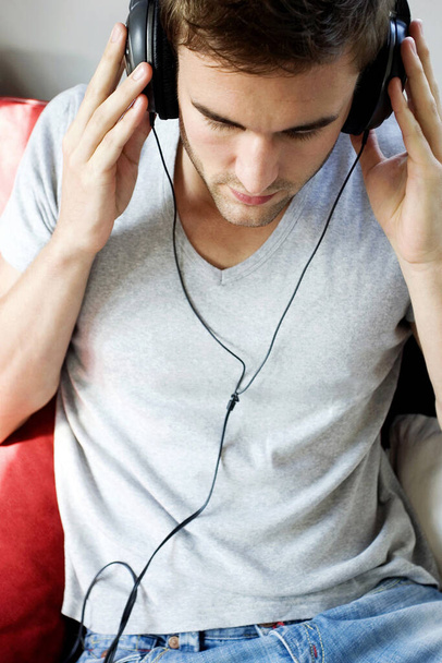 A man holding the headphone, listening to music - Foto, Bild