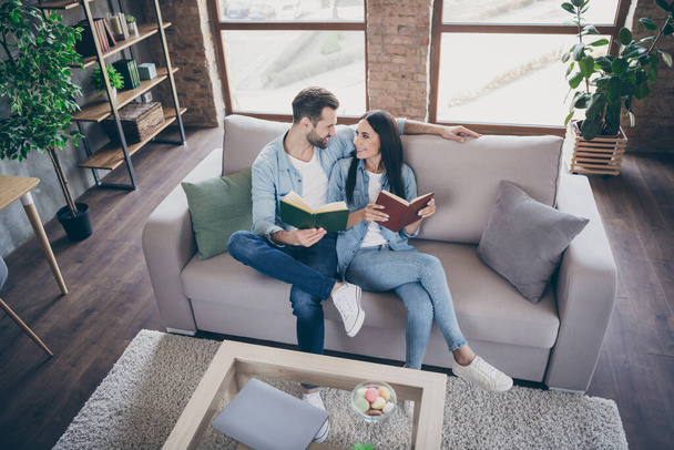Top above high angle view full size photo of passionate affectionate couple man woman look enjoy reading book hobby sit couch in house indoors - Фото, зображення