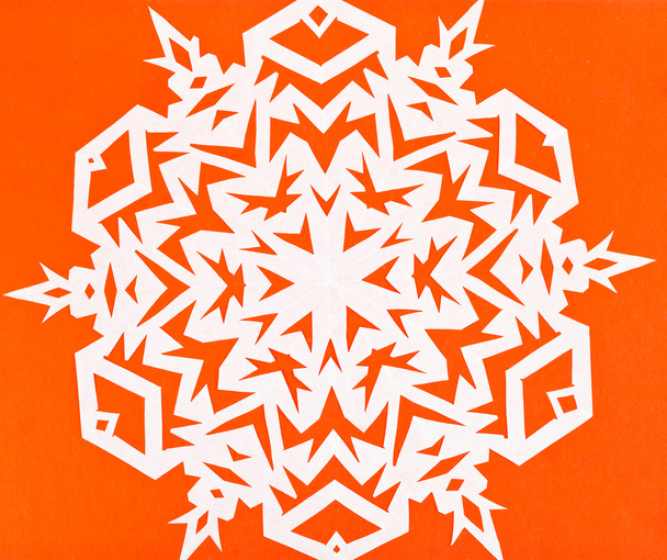 valkoinen lumihiutale oranssilla paperilla
 - Valokuva, kuva