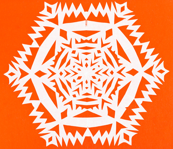オレンジ色の紙の上の白い雪片 - 写真・画像