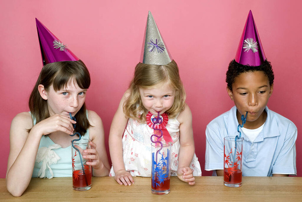 Kids with party hats drinking - Фото, зображення