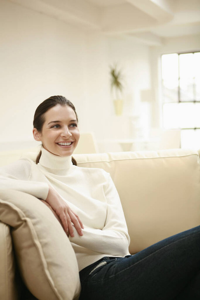Smiling woman sitting on couch - Photo, image