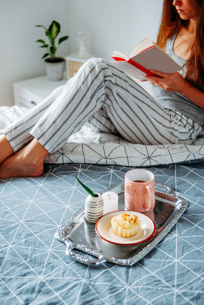 Goedemorgen snack. Cottage kaas muffin en thee. Vroeg ontbijt. meisje reaging in haar bed. - Foto, afbeelding
