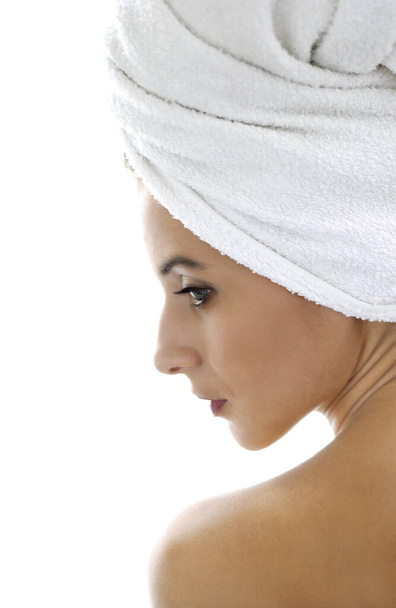 Side shot of a woman with her hair wrapped up in towel - Foto, afbeelding