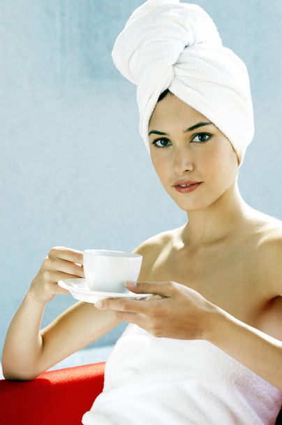 タオルを着た女がコーヒーを飲みながら - 写真・画像