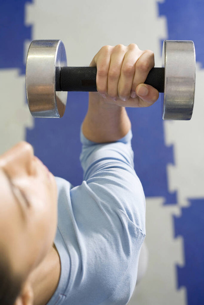 young Woman lifting dumbbell - Foto, imagen