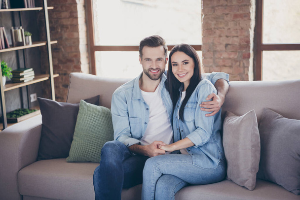 Portrait of positive cheerful spouses man woman hug embrace enjoy quarantine stay home together sit couch in house room indoors - Fotoğraf, Görsel