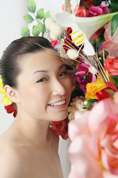 Woman posing beside floral background - Фото, зображення